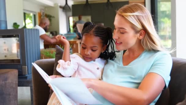 怀孕的母亲和女儿和家人一起在家里看书 动作缓慢 — 图库视频影像