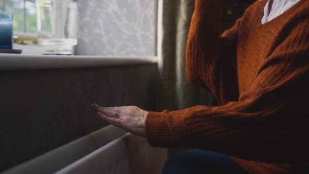 Крупный План Пожилой Женщины Сидящей Радиатора Дома Пытаясь Согреться Время — стоковое видео