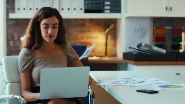在现代写字楼的办公桌前工作的年轻的微笑的女商人 动作缓慢 — 图库视频影像
