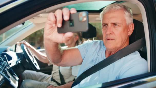 当一对老夫妇一起开车旅行观光时 一起从乘客窗口往外看 用手机慢镜头拍照 — 图库视频影像
