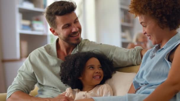 Filha Sentada Com Pais Sofá Casa Puxando Rostos Engraçados Filmado — Vídeo de Stock