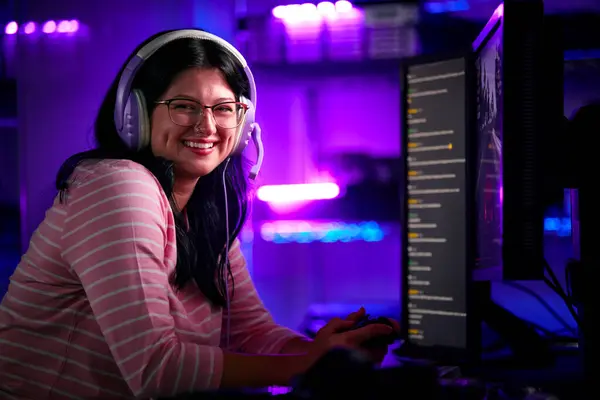 带耳机和控制器的电脑屏幕前女性游戏玩家的肖像 — 图库照片
