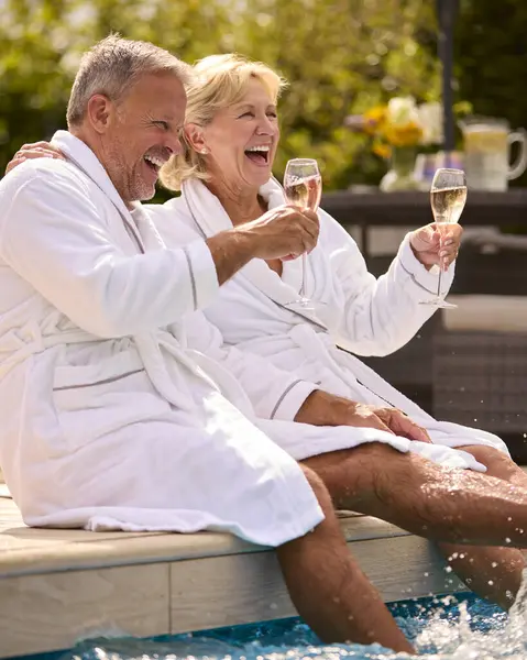 Senior Par Robes Utomhus Dricka Champagne Genom Att Simma Pool — Stockfoto