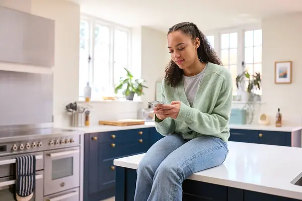 Teenage Girl Home Kitchen Island Connecting Friends Social Media Using — Stock Photo, Image