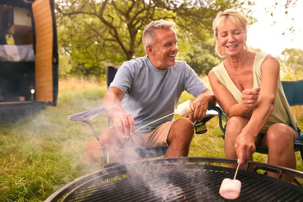 Senior Couple Kempingi Countryside Toasting Marshmallows Outdoors Fire — Zdjęcie stockowe