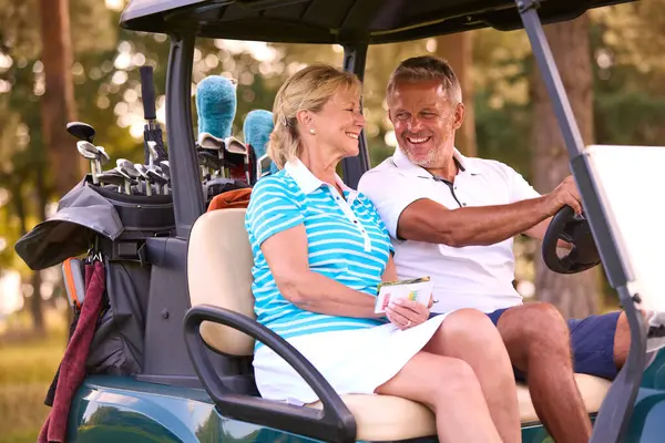 Seniorenpaar Sitzt Buggy Auf Golfplatz Und Markiert Punktekarte Stockbild