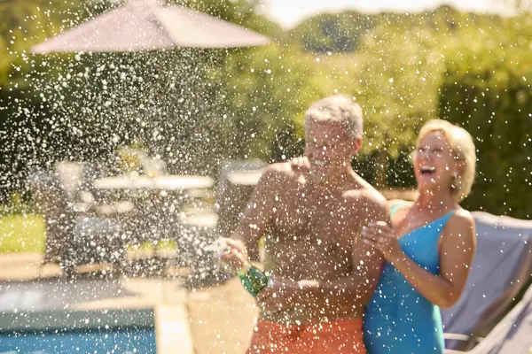 Oudere Paar Vakantie Zwemkleding Opening Champagne Door Hotel Zwembad — Stockfoto