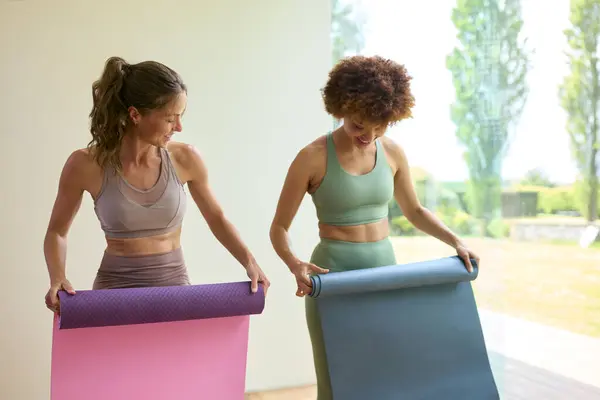 Dois Amigos Femininos Vestindo Roupas Fitness Desrolando Tapetes Exercício Aula — Fotografia de Stock