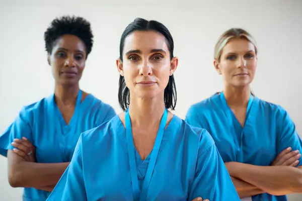 Portrait Of Mature Female Multi Cultural Medical Team Wearing Scrubs In Hospital