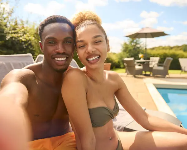 ホテルのプールでスイミングコスチュームを着用するセルフィーのための休日のカップルのPovショット — ストック写真
