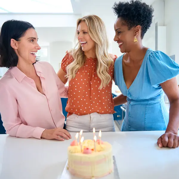 Three Mature Women Meeting At Home To Celebrate Friend\'s Birthday With Surprise Cake Together