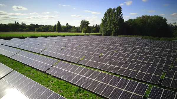田舎で再生可能な持続可能なエネルギーを生成するフィールドでの太陽光パネルの空気ドローンショット — ストック写真