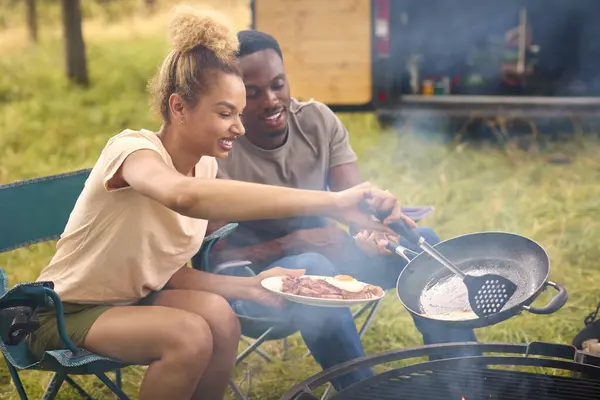 火の朝食の屋外のためのRvの調理のベーコンそして卵が付いているカップルのキャンプ — ストック写真