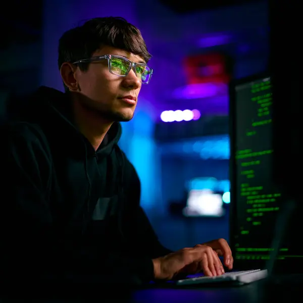 男子计算机黑客坐在屏幕前破坏网络安全的低调照明镜头 — 图库照片