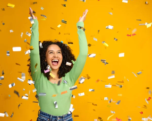イエローバックグラウンドでタンデコンセッティで大勝利を祝う興奮した女性のスタジオショット — ストック写真