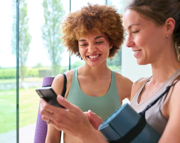Zwei Freundinnen Schauen Aufs Handy Und Tragen Turnbekleidung Fitnessstudio Oder — Stockfoto