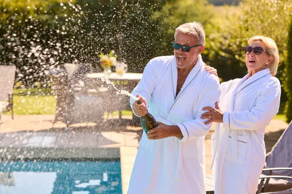 Oudere Paar Vakantie Dragen Gewaden Opening Champagne Door Hotel Zwembad — Stockfoto