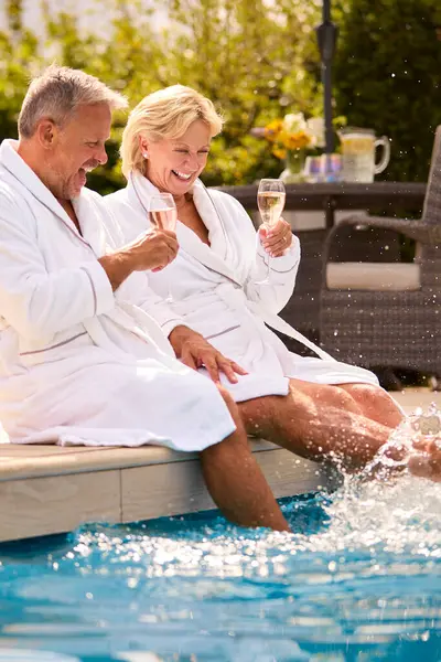 Senioren Paar Gewaden Buiten Drinken Champagne Door Zwembad Spetteren Het — Stockfoto
