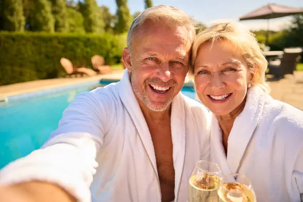水疗日用游泳池在户外喝香槟的老年情侣长袍Pov镜头 — 图库照片
