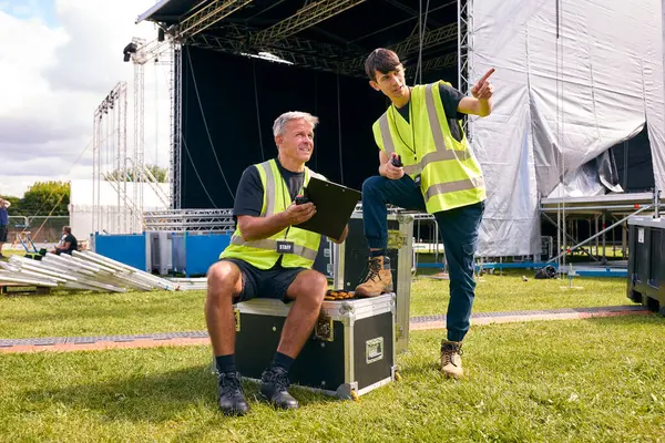 音楽祭のための屋外ステージを設定するフライトケースを持つ男性の生産チーム — ストック写真