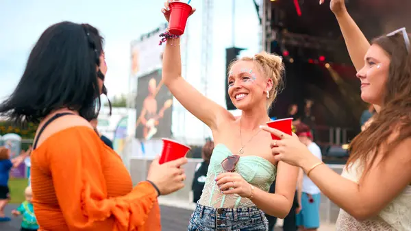 Drei Freundinnen Glitzeranzügen Amüsieren Sich Bei Sommerlichem Musikfestival Mit Drinks Stockbild