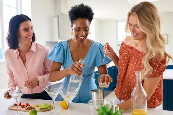 Three Mature Female Friends Home Having Fun Mixing Cocktails Together Stock Picture