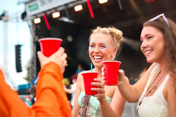 Três Amigas Usando Glitter Divertindo Festival Música Verão Segurando Bebidas Imagens De Bancos De Imagens Sem Royalties