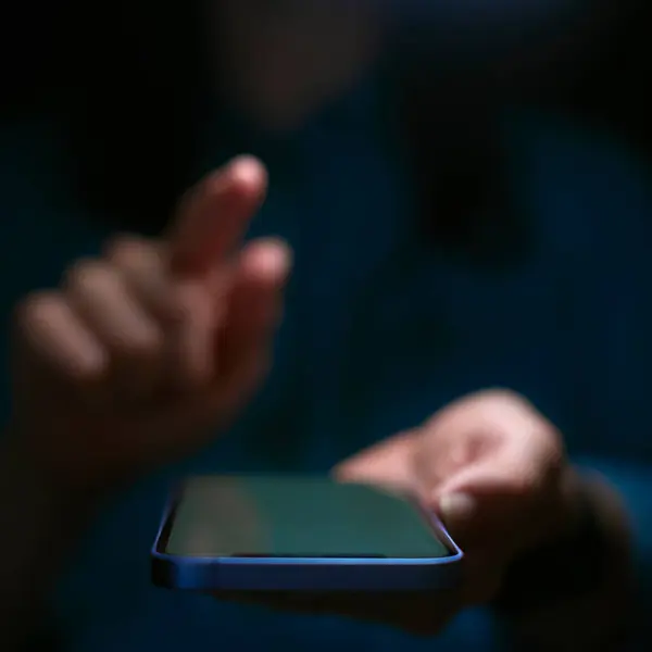 フィンガーと携帯電話を使用した女性のクローズアップ 画面上にポーズ ストック画像
