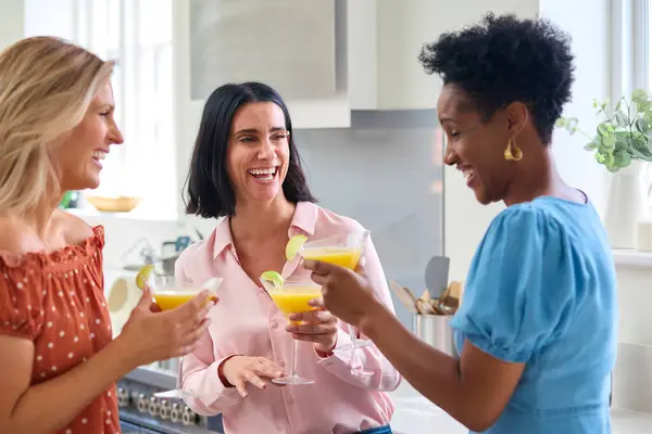 Three Mature Female Friends At Home Celebrating With Cocktails Together