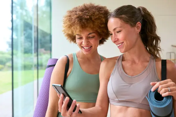 Two Female Friends Look Mobile Phone Wearing Gym Clothing Gym — Stock Photo, Image
