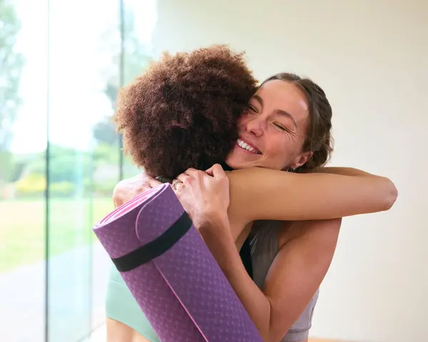 Kvindelige Venner Iført Gymnastik Tøj Møde Kramme Gym Eller Yoga - Stock-foto