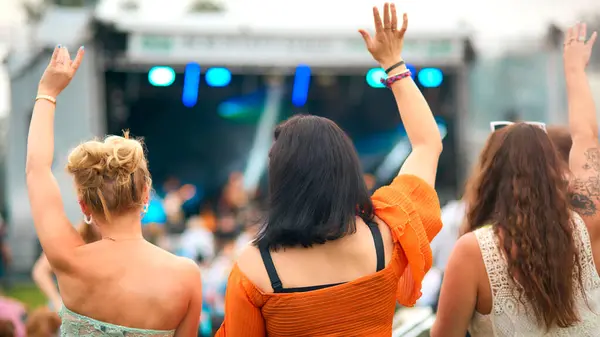 三个女性朋友在夏季音乐节跳舞的背景图 图库图片