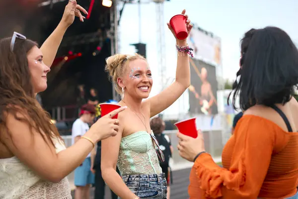 Três Amigas Usando Glitter Divertindo Festival Música Verão Segurando Bebidas Fotografias De Stock Royalty-Free