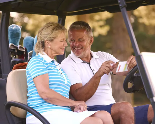 Casal Sênior Sentado Buggy Campo Golfe Marcando Cartão Pontuação Juntos — Fotografia de Stock