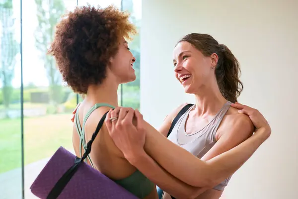 Two Female Friends Wearing Gym Clothing Meeting Hugging Gym Yoga — Stock Photo, Image