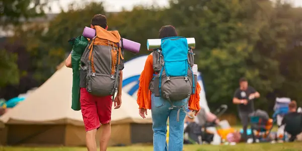 Rückansicht Junges Paar Trifft Sich Beim Sommer Musikfestival Mit Campingausrüstung lizenzfreie Stockbilder