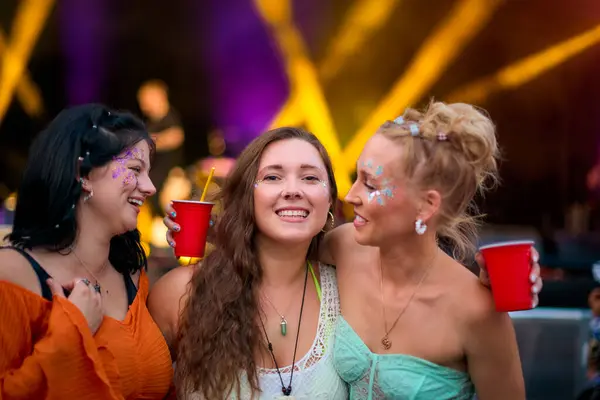 Tre Kvinnelige Venner Iført Glitter Det Gøy Sommermusikkfestival Holder Drinker stockbilde