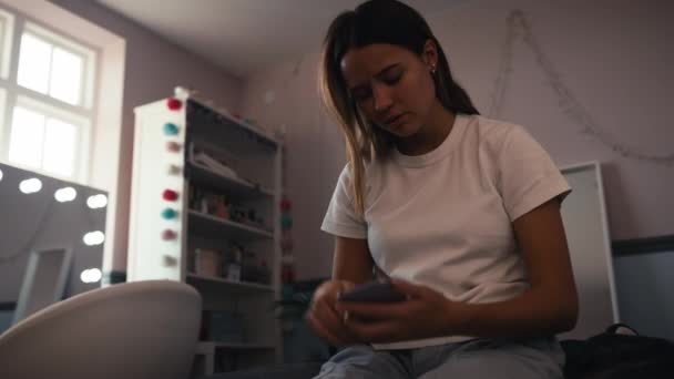 Nedstämd Tonåring Som Sitter Sängen Hemma Och Tittar Mobbningsmeddelanden Mobilen — Stockvideo
