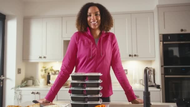 キッチンで笑顔の女性の肖像画 フィットネス服を着て冷蔵庫のために事前に健康的な食事を作る スローモーションで撮影 — ストック動画