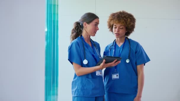 Twee Vrouwelijke Artsen Dragen Scrubs Met Digitale Tablet Bespreken Patiëntennota — Stockvideo