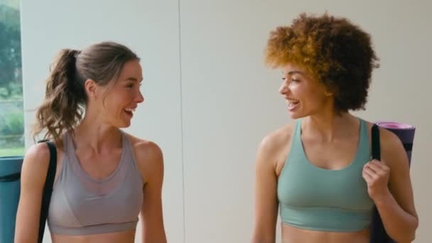 Dos Amigas Que Reúnen Llevando Colchonetas Ejercicio Gimnasio Estudio Yoga — Vídeo de stock