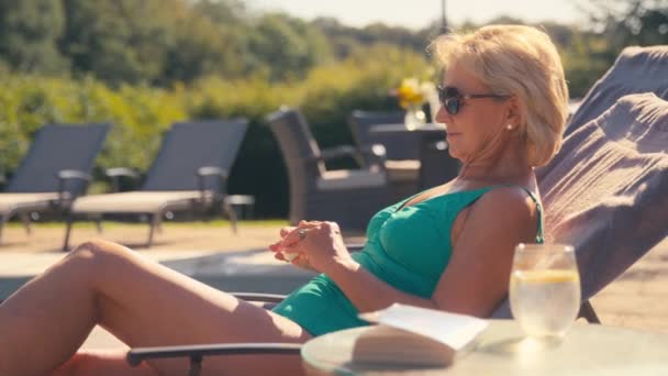 Starsza Emerytka Kostiumie Kąpielowym Okularach Przeciwsłonecznych Relaksująca Się Przy Hotelowym — Wideo stockowe