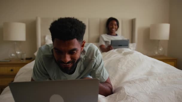 Пара Вдома Ліжку Чоловіком Який Використовує Ноутбук Жінку Цифровому Планшеті — стокове відео