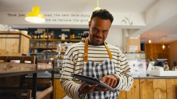 Lächelnder Mann Mit Syndrom Arbeitet Lebensmittelladen Mit Digitalem Tablet Aufgenommen — Stockvideo