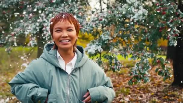 雪が降る冬の田舎で外に立っているコートを着て笑う若い女性 ゆっくりとした動きで撮影 — ストック動画