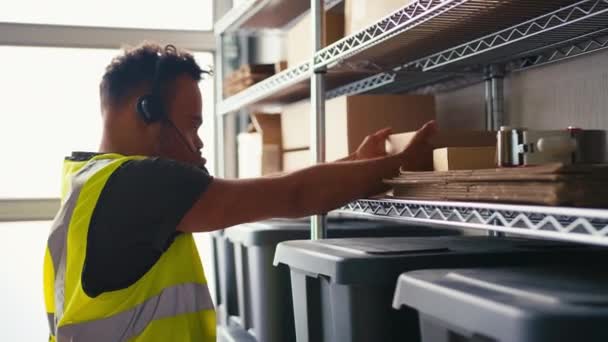 Άνθρωπος Σύνδρομο Εργάζεται Στην Αποθήκη Διανομής Φορώντας Ακουστικά Λαμβάνοντας Κουτί — Αρχείο Βίντεο