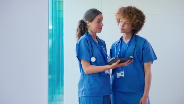 Twee Vrouwelijke Artsen Dragen Scrubs Met Digitale Tablet Bespreken Patiëntennota — Stockvideo