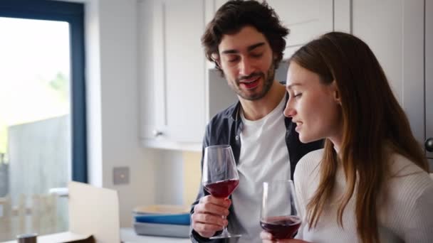 Pasangan Bersemangat Merayakan Dengan Segelas Anggur Merah Dapur Rumah Baru — Stok Video