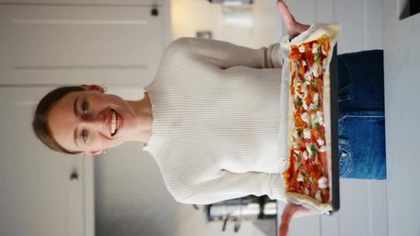 Вертикальне Відео Молодої Усміхненої Жінки Кухні Вдома Тримає Свіжу Піцу — стокове відео