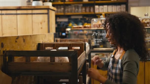 Lächelnde Junge Frau Die Einem Lebensmittelladen Regale Mit Brot Stapelt — Stockvideo